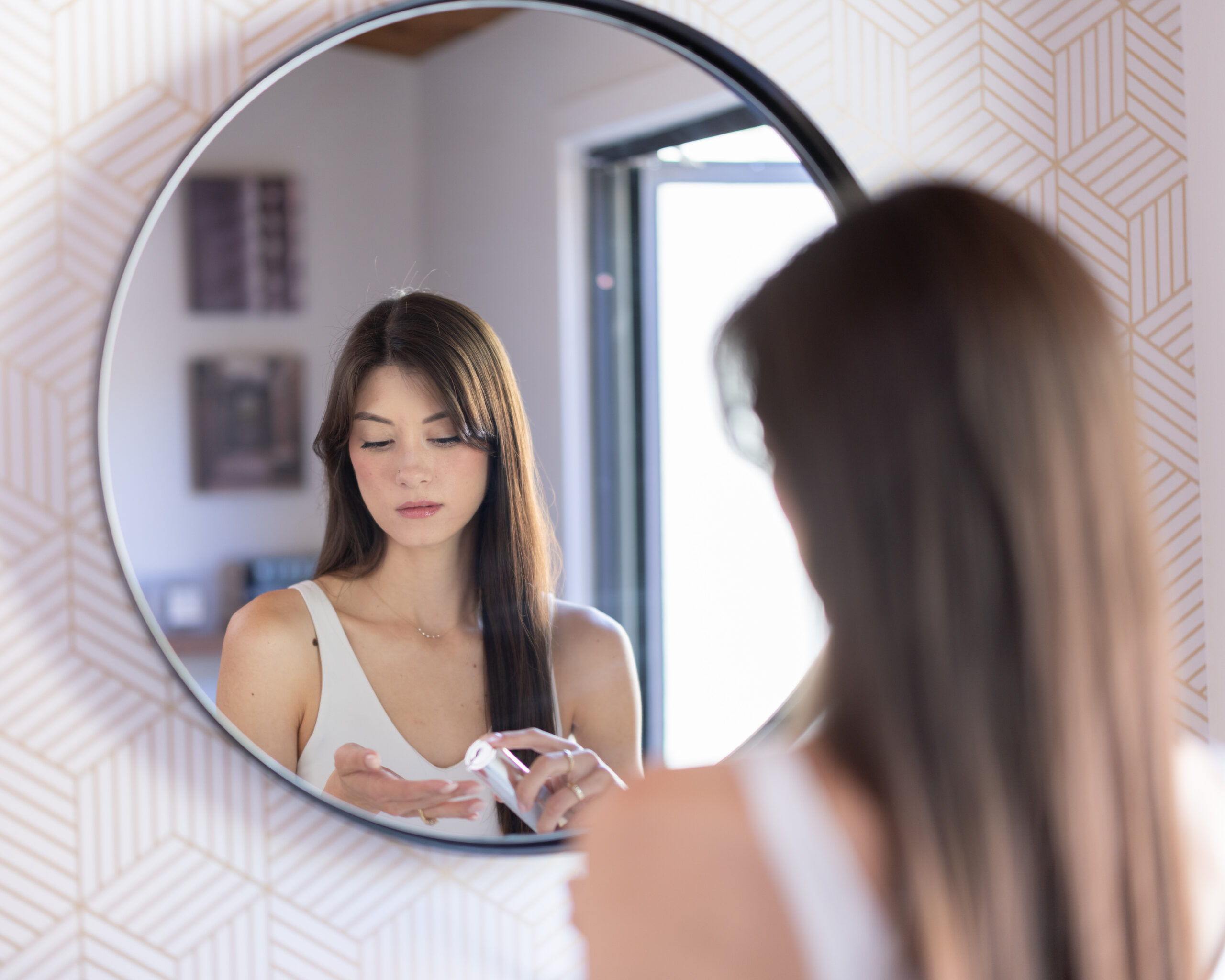 Woman beginning her daily personal-care routine at a mirror